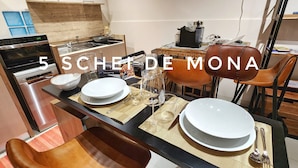 A modern kitchen with a dining area set for a meal. - The 5 Schei De Mona Concierge Services in Venice (Venice)