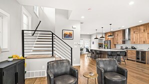 Una cocina moderna con armarios de madera, una isla central e iluminación colgante.