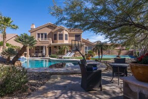 A large house with a swimming pool, outdoor furniture, and a well-maintained garden. - Desert Paradise, Pool, Spa, Pickleball, Putt Green (Phoenix)