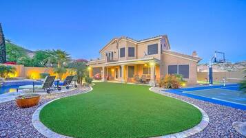 Relax on the balcony with outdoor seating, overlooking the well-maintained lawn and pool.