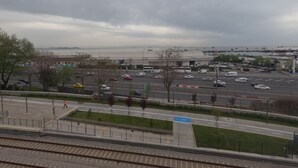 A parking lot with multiple vehicles, a building with a flat roof, and a body of water in the background. - MS kuba Istanbul apart (Istanbul)
