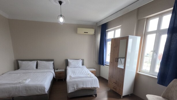 A hotel room with two beds, a wardrobe, a chair, and a window with curtains. - MS kuba Istanbul apart (Istanbul)