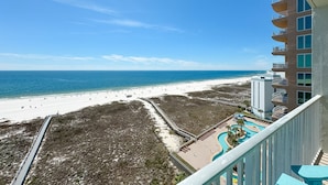 A beach view from a balcony overlooking a resort area with a pool and a boardwalk. - Tidewater 907-Family friendly complex to enjoy the Beach! (Orange Beach)