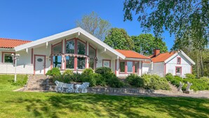 A two-story house with a red-tiled roof, large windows, and a stone staircase leading to the entrance. - Lovely home in Söderköping with sauna (Söderköping)