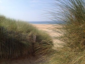 A beach with sand dunes and a clear view of the ocean.
