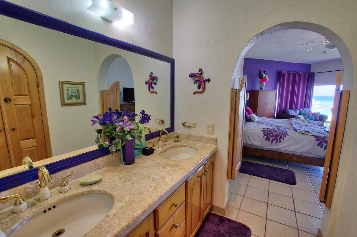 A bathroom with two sinks, a mirror, and a vanity.