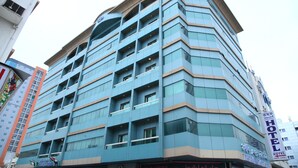 Un hôtel à plusieurs étages, doté d’une architecture moderne, et dont la façade est ornée d’une grande enseigne indiquant « HÔTEL ».