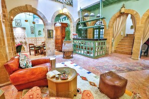 A cozy interior with a leather sofa, a wooden coffee table, and a patterned rug. - Ryad des Nomades (Essaouira)