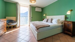 Quarto com cama, uma cadeira, cômoda e mesa de cabeceira.