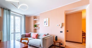 A modern living room with a sofa, a dining table, and a small side table. - Lakefront Retreat - Salvia (Bellagio)