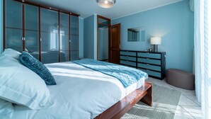 Ein Schlafzimmer mit Bett, Schrank, Kommode und Spiegel.