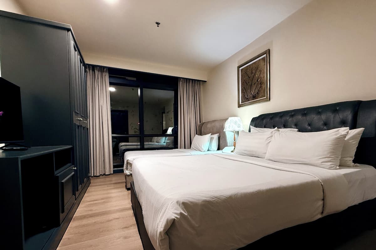 A hotel room with a large bed, a desk, and a television.
