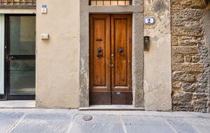A double wooden door with a metal handle, a mailbox, and a stone wall. - Tornabuoni Place & Dream by Mmega (Florence)