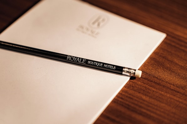 A black pencil with 'ROYALE BOUTIQUE HOTELS' text lying on a white paper. - Royale Sainte Hélène Boutique Hotel (Birkirkara)