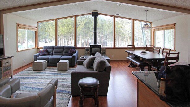 A spacious living room with a large window, a fireplace, and a dining area.