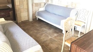 Quarto com sofá, poltrona e cama.