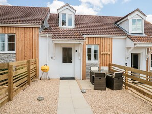 A residential property with a gravel driveway, wooden fences, a barbecue grill, and a sign reading "Mellstock". - Mellstock (Weymouth)