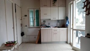 A kitchen with white cabinets, a window, and a door. - Cod Citra 008031-lt-1216 Affitto Pittoresca Casina Indipendente con Giardino (Imperia)