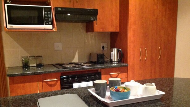 Una cocina con encimeras de granito, microondas, estufa y armarios.