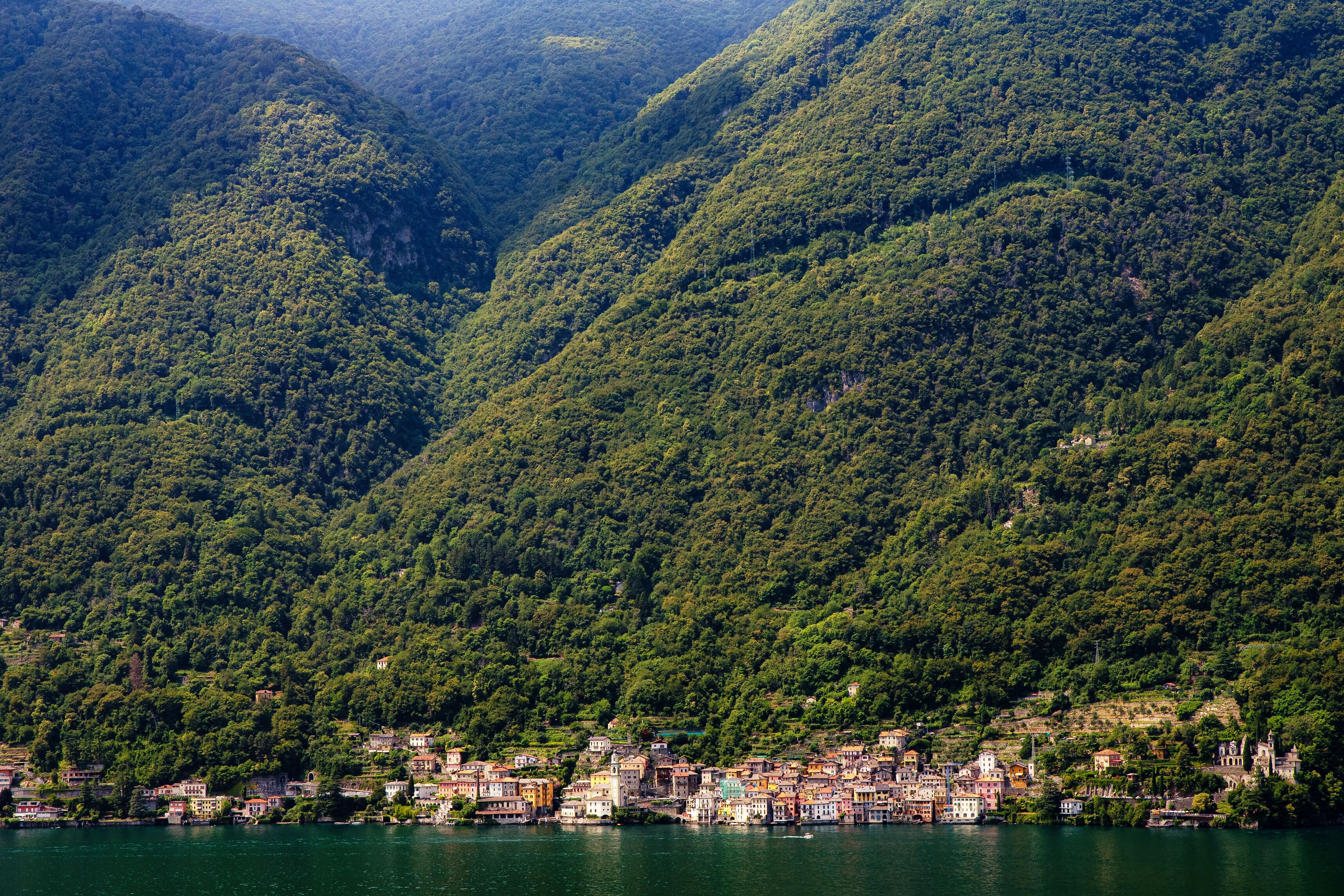 Un pueblo a orillas del lago, ubicado en un valle rodeado de colinas cubiertas de bosques densos.