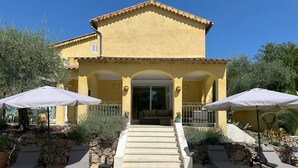 A yellow building with a pool, outdoor seating, and a staircase leading to the entrance. - Villa Ocre, in Provence Verte, between the Mediterranean and the Gorges du Verdon. (Lorgues)
