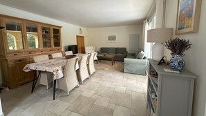 A spacious living area with a dining table, chairs, a sofa, and a lamp. - Villa Ocre, in Provence Verte, between the Mediterranean and the Gorges du Verdon. (Lorgues)