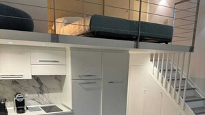 A compact living space with a kitchenette, dining area, and a sofa.