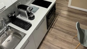 A modern kitchen with a built-in stove, a sink, and a compact countertop.
