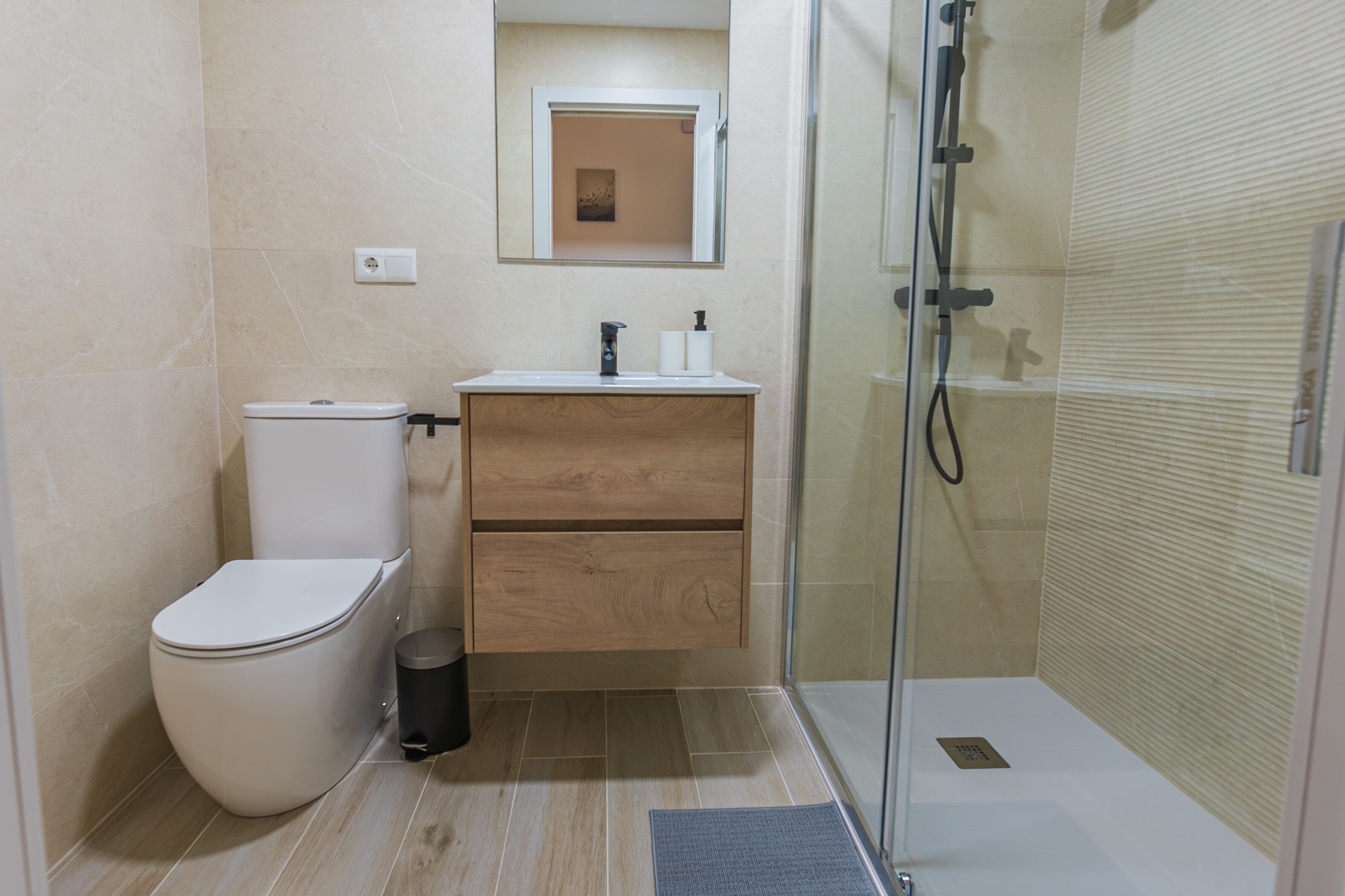 Un baño moderno con inodoro, lavamanos y ducha.