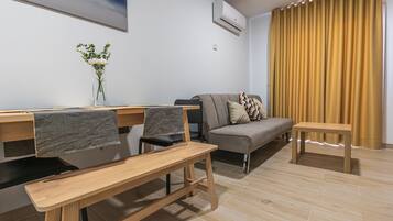 Una sala de estar moderna con un sofá, una mesa de comedor y sillas.
