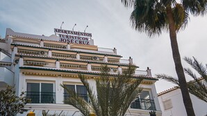 A multi-story building with balconies and a sign that reads "Apartamentos Turísticos José Cruz". - Apartamentos turisticos Jose Cruz  (Nerja)