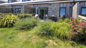 A modern house with a stone facade, wooden exterior, and multiple windows. - Overcombe Mill (Weymouth)