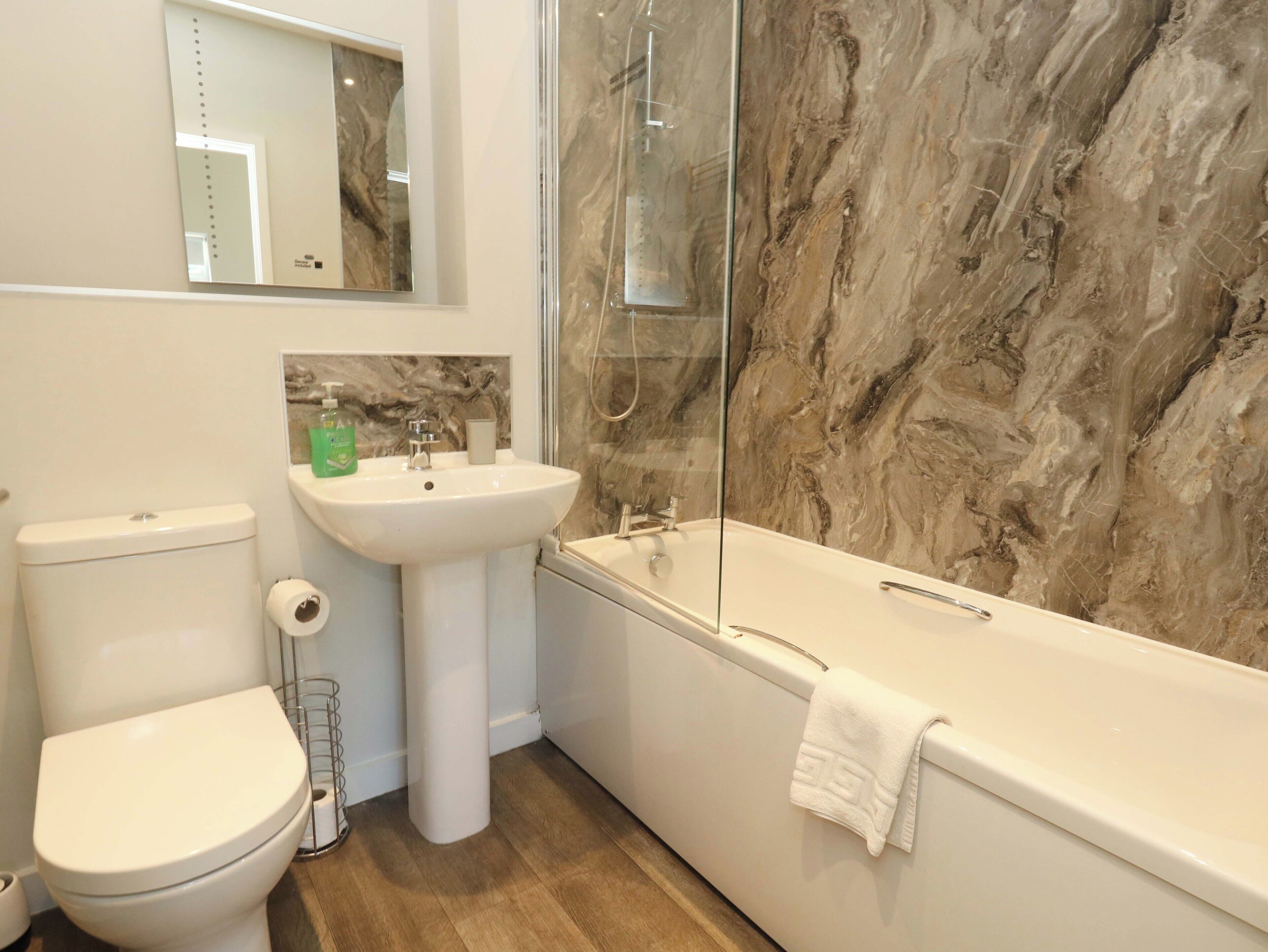 A bathroom with a toilet, sink, and bathtub.
