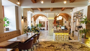 A modern interior with a dining area, seating, and a bar. - ART HOTEL (Sibiu)