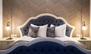 A bedroom with a tufted headboard, two bedside tables with lamps, and a herringbone-patterned wall. - ART HOTEL (Sibiu)