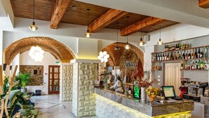A bar area with a marble counter, wooden beams, and a brick wall. - ART HOTEL (Sibiu)