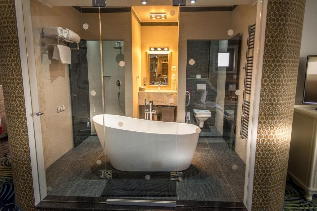 A modern bathroom with a freestanding bathtub, a glass-enclosed shower, and a vanity with a mirror.