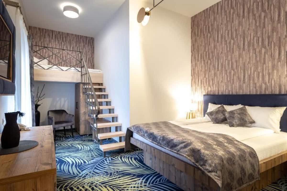 A modern bedroom with a bunk bed, a desk, and a chair.
