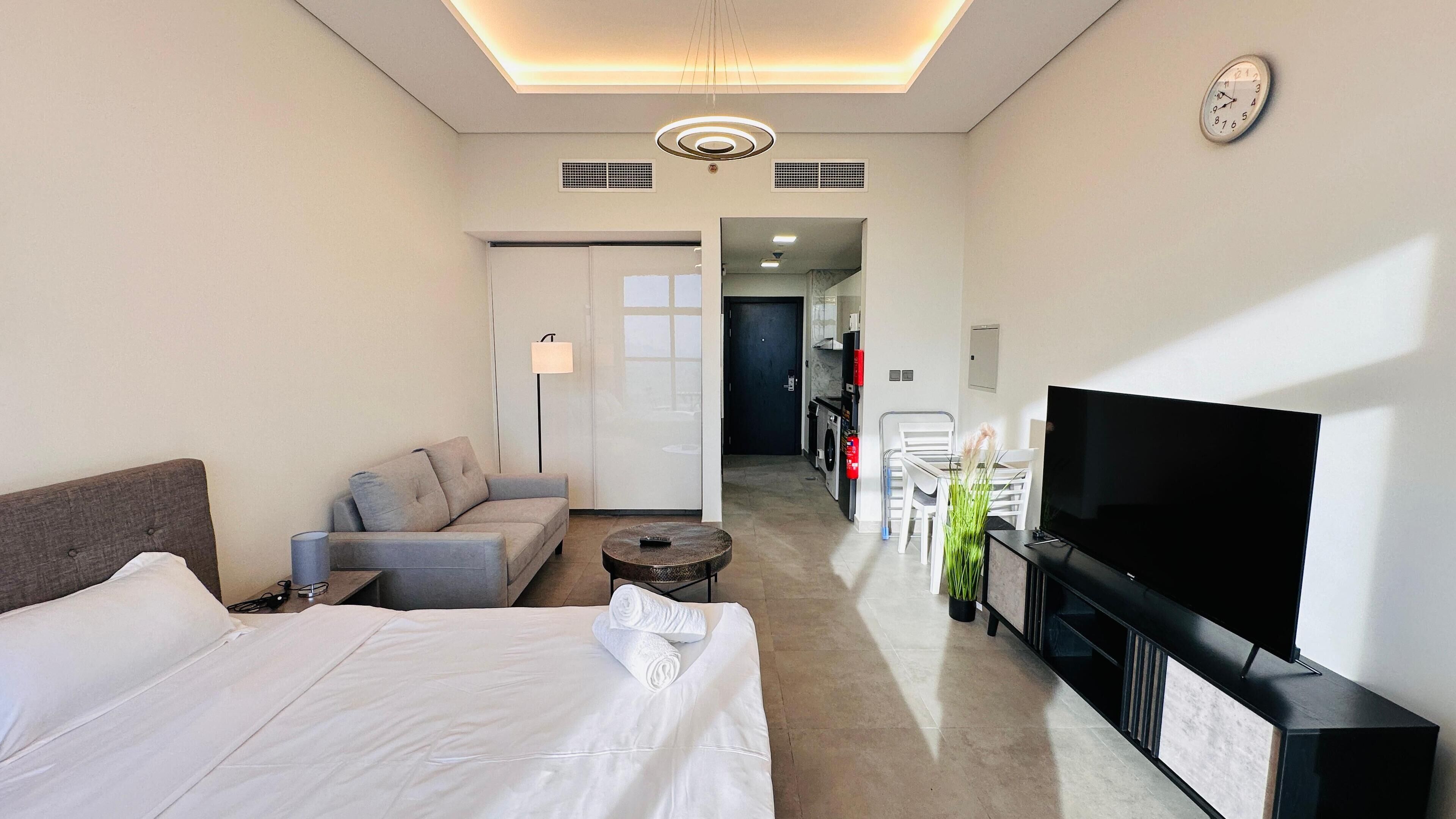 Et hotelværelse med seng, sofa, fjernsyn og et lille bord.