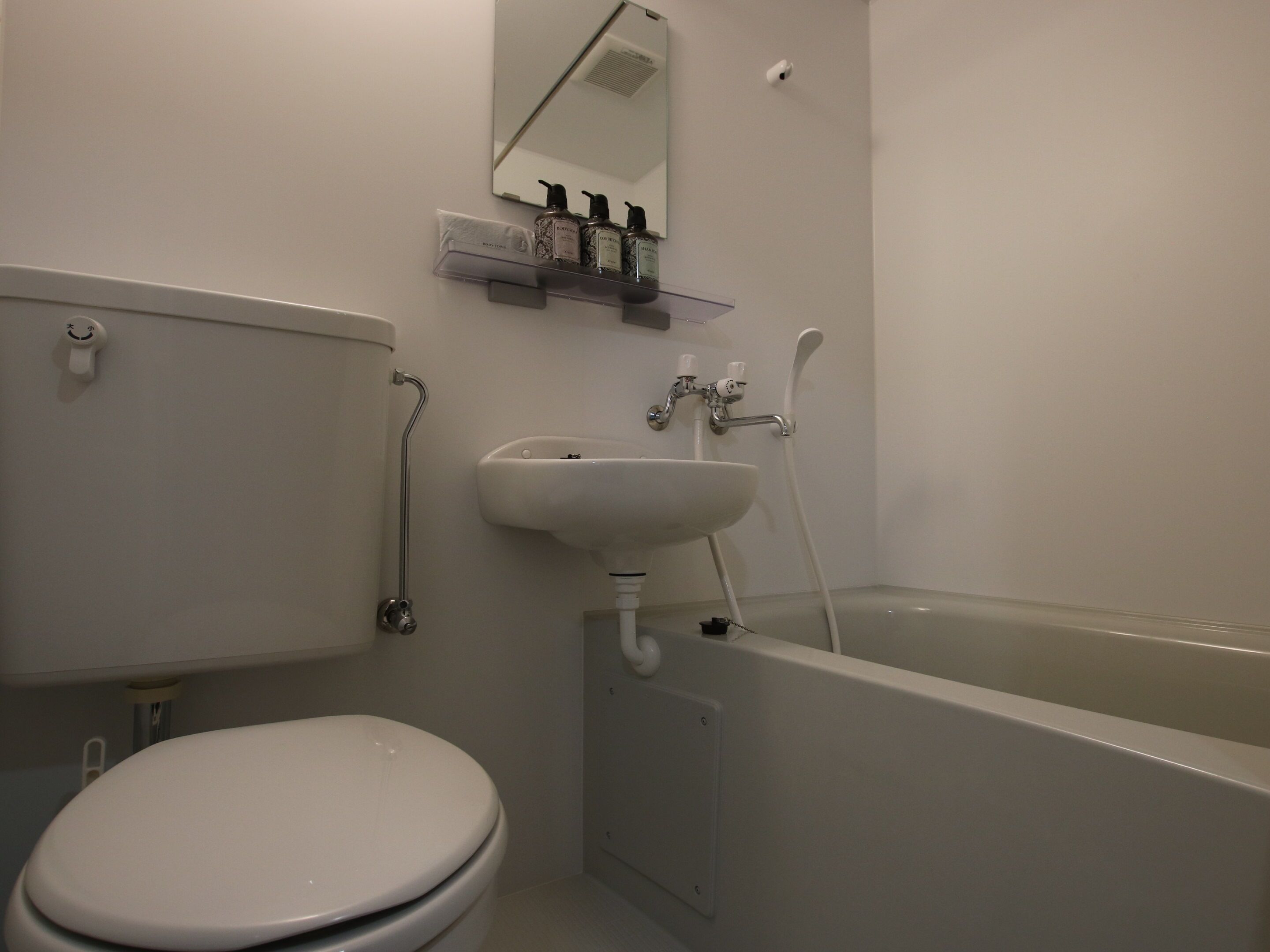 A bathroom with a toilet, sink, and bathtub.
