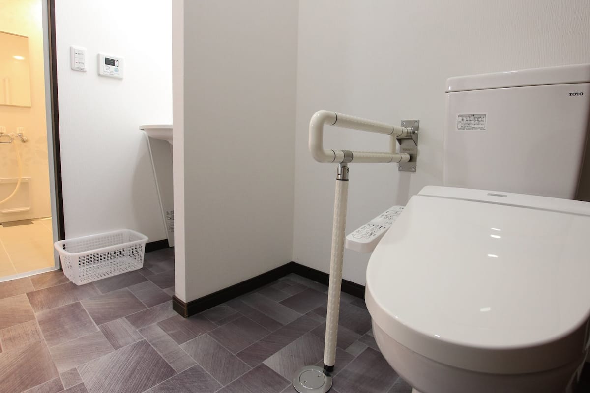A bathroom with a white toilet, a white sink, and a shower area.