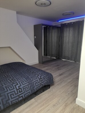 A bedroom with a bed, a wardrobe, and a sliding door leading to a balcony.