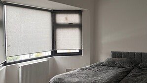 Une chambre à coucher avec un lit, une fenêtre et un radiateur.