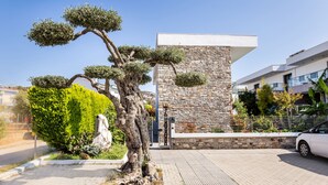 A modern building with a stone facade and a tree in the foreground. - Village Esperia  (Thasos)