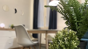 Uma cozinha moderna com uma mesa de jantar, cadeiras e plantas em vasos.