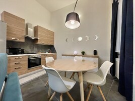 Una cocina moderna con armarios de madera, una mesa de comedor redonda y sillas blancas.