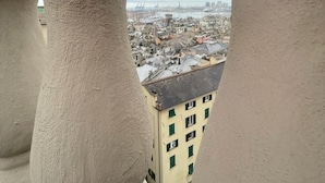 Vista através de um parapeito de pedra, com vista para a cidade e o porto.