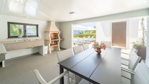 Una cocina moderna con horno integrado y comedor con mesa y sillas.