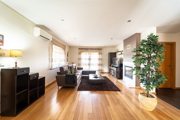 A modern living room with a sofa, coffee table, and a potted plant.