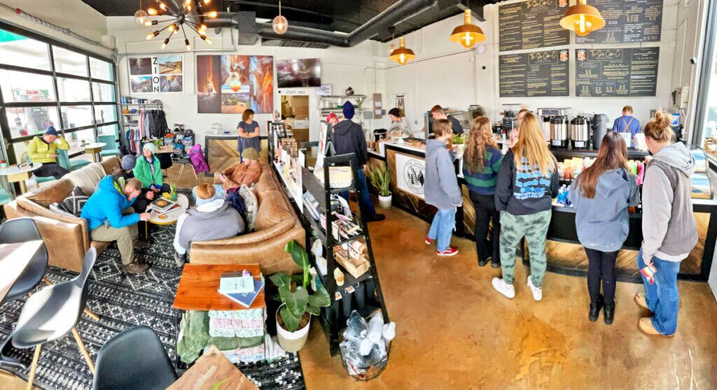 A café with a counter, seating area, and a menu board.